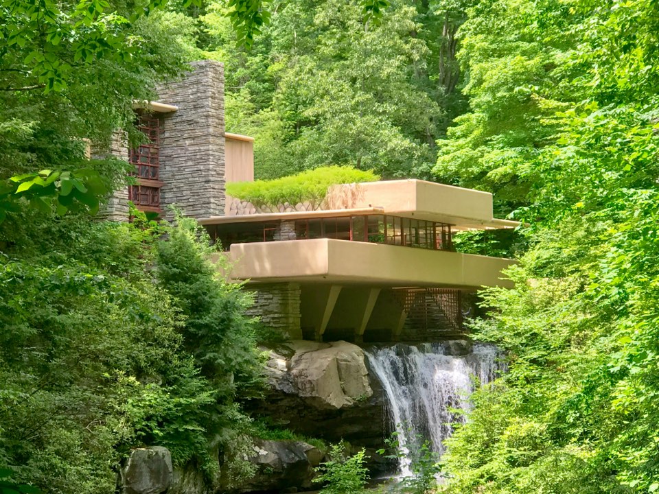 Fallingwater cantilevered over the waterfall, the cascade spilling from the rock beneath the house