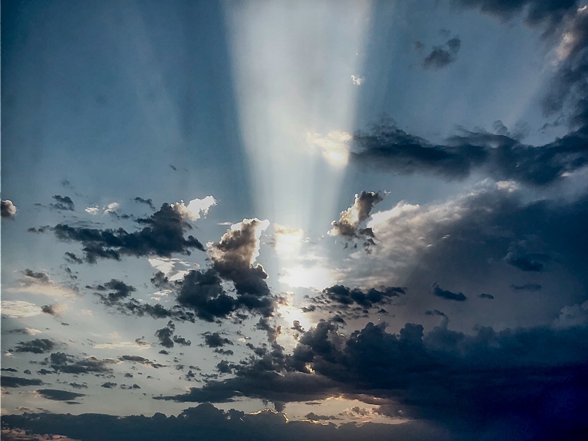 Crepuscular sunbeams breaking through dark storm clouds over the desert sky in Las Vegas