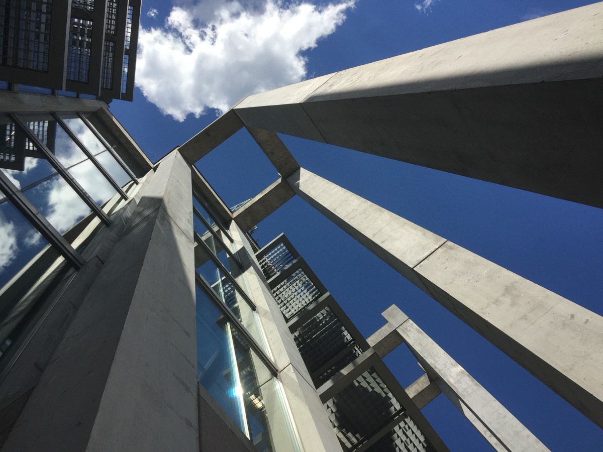 Concrete beams and glass of the Great Hall converging toward a blue sky at the National Gallery of Canada, Ottawa